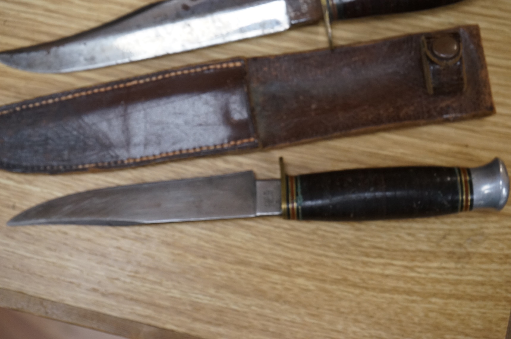 A 1907 bayonet by Wilkinson in its steel mounted leather scabbard, another similar with leather frog, two small British bayonets, a Continental bayonet, and two assorted hunting knives (7)